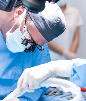 A male dentist performing a dental implant surgery
