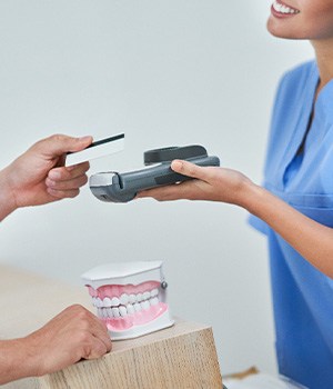 A patient paying the cost of their dental care