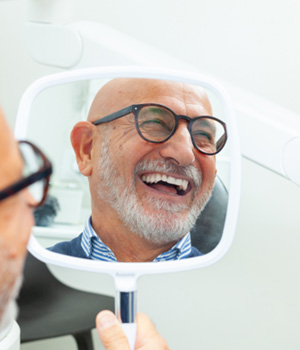 Man with black glasses smiling in reflection