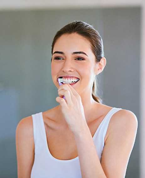 Woman brushing her teeth in bathroom