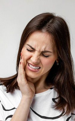 a woman gritting her teeth because of tooth pain